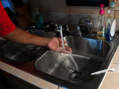 Timbo Payne checks the water pressure in his kitchen at his home on September 3, 2022 in Jackson, Mississippi.