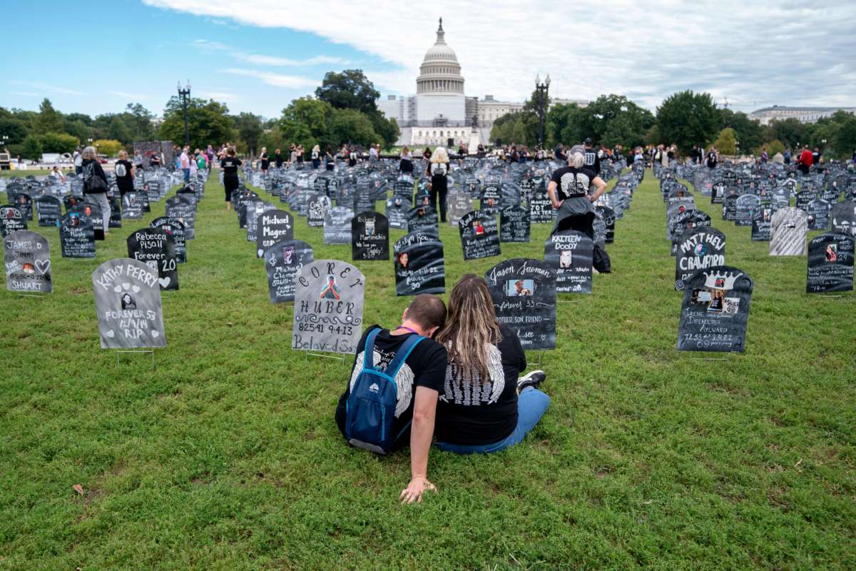 People who lost relatives to a drug overdose sit among imitation graves set up near the US Capitol in Washington, DC, on September 24, 2022.