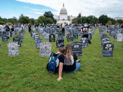 People who lost relatives to a drug overdose sit among imitation graves set up near the US Capitol in Washington, DC, on September 24, 2022.