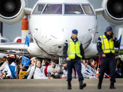 Milieudefensie, Extinction Rebellion, Greenpeace and other organizations' members sit in front of an aircraft during a climate action protest at Schiphol Airport, near Amsterdam on November 5, 2022.