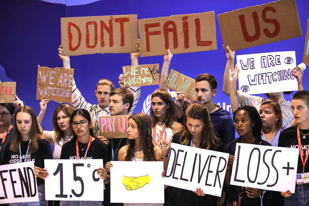 Climate activists holding signs that say "Don't Fail Us" protest at COP27