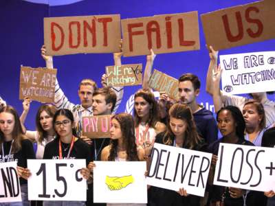 Climate activists holding signs that say "Don't Fail Us" protest at COP27