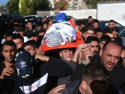 Palestinians carry the body of 16 year old Ahmed Emced Shehade who was shot and killed by Israeli forces during a raid in Nablus, West Bank on November 23, 2022.