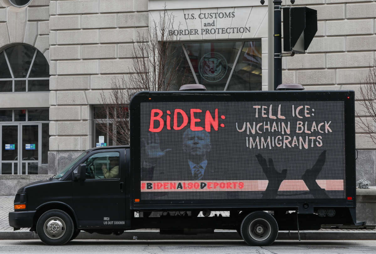 Truck with a sign saying "Biden: Tell ICE to Unchain Black Immigrants" outside of U.S. Customs and Border Protection building