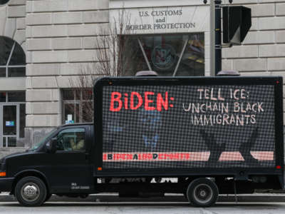 Truck with a sign saying "Biden: Tell ICE to Unchain Black Immigrants" outside of U.S. Customs and Border Protection building