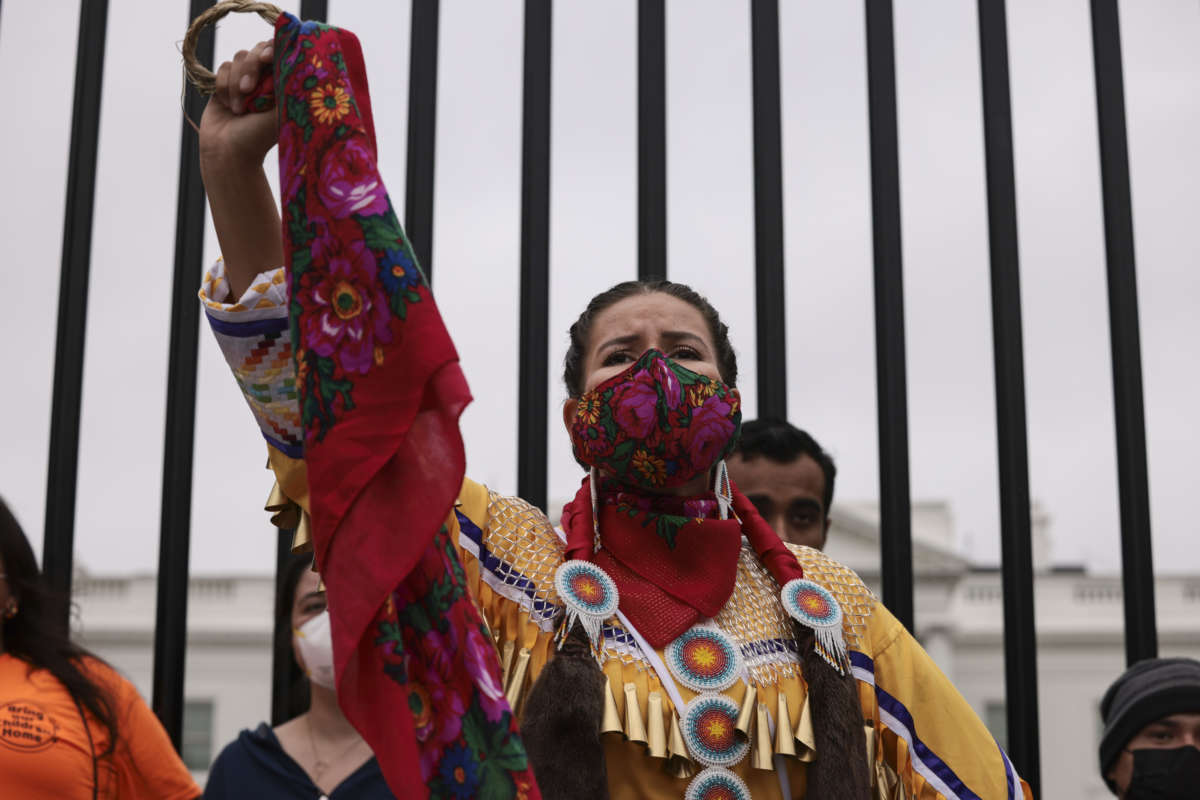 A demonstrator holds up her fist in front of the White House during a climate march in honor of Indigenous Peoples’ Day on October 11, 2021, in Washington, D.C.