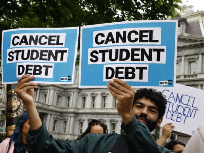 Protestor holds a sign saying "cancel student debt"