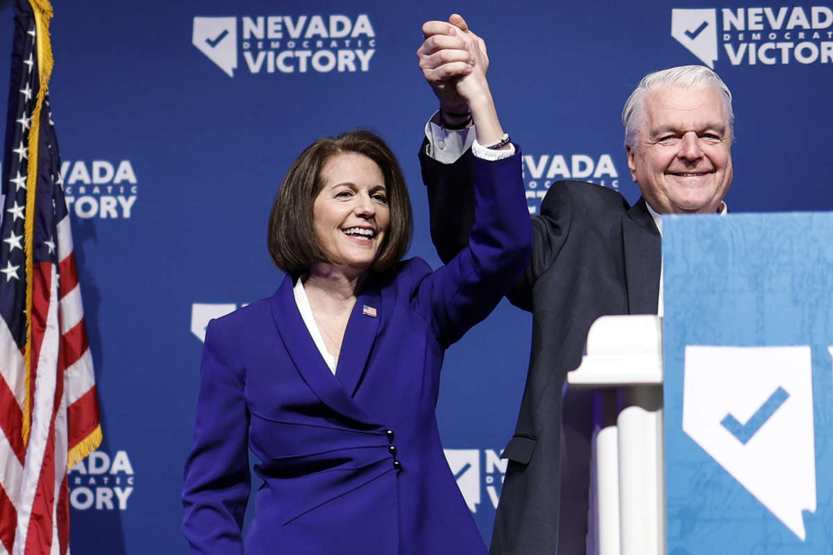 U.S. Sen. Catherine Cortez Masto and Nevada Gov. Steve Sisolak hold their hands up after giving remarks at an election night party hosted by Nevada Democratic Victory on November 8, 2022 in Las Vegas, Nevada.