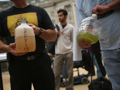 Craig Stevens, left, of Silver Lake Township, Pennsylvania, and Ray Kemble, right, of Dimock, Pennsylvania, show water samples collected from Dimock, Pennsylvania, during a rally on fracking-related water investigations, on October 10, 2014, outside the EPA's Headquarters in Washington, D.C.