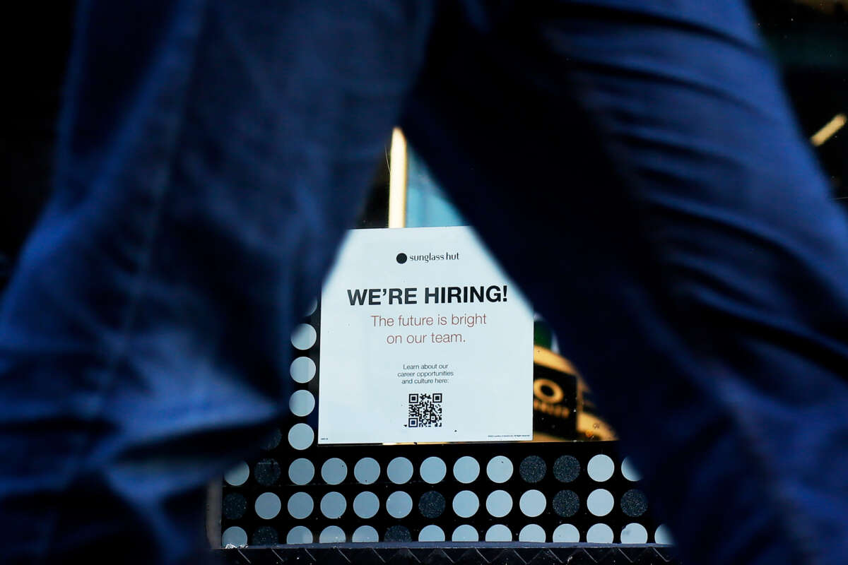 A Now Hiring sign is displayed on a shopfront on October 21, 2022, in New York City.