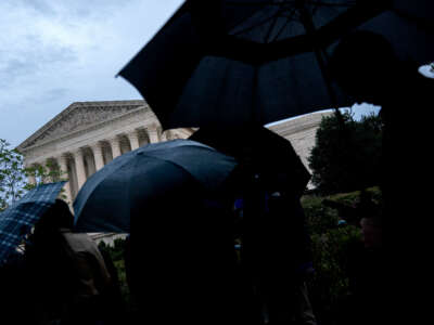 People hold umbrellas while standing in line outside the Supreme Court building in Washington, D.C., on October 3, 2022.