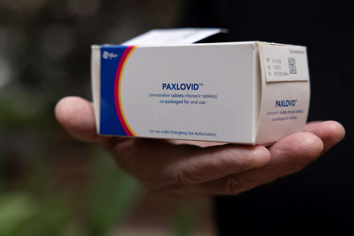 A hand holds up a box of Paxlovid, the Pfizer drug for COVID-19