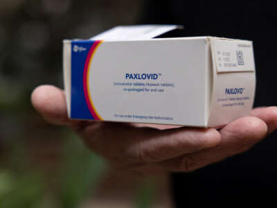A hand holds up a box of Paxlovid, the Pfizer drug for COVID-19
