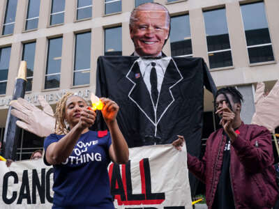 Maddy Clifford burns a slip of paper representing her debt in front of the Department of Education as part of the Debt Collective Day of Action in April 2022.