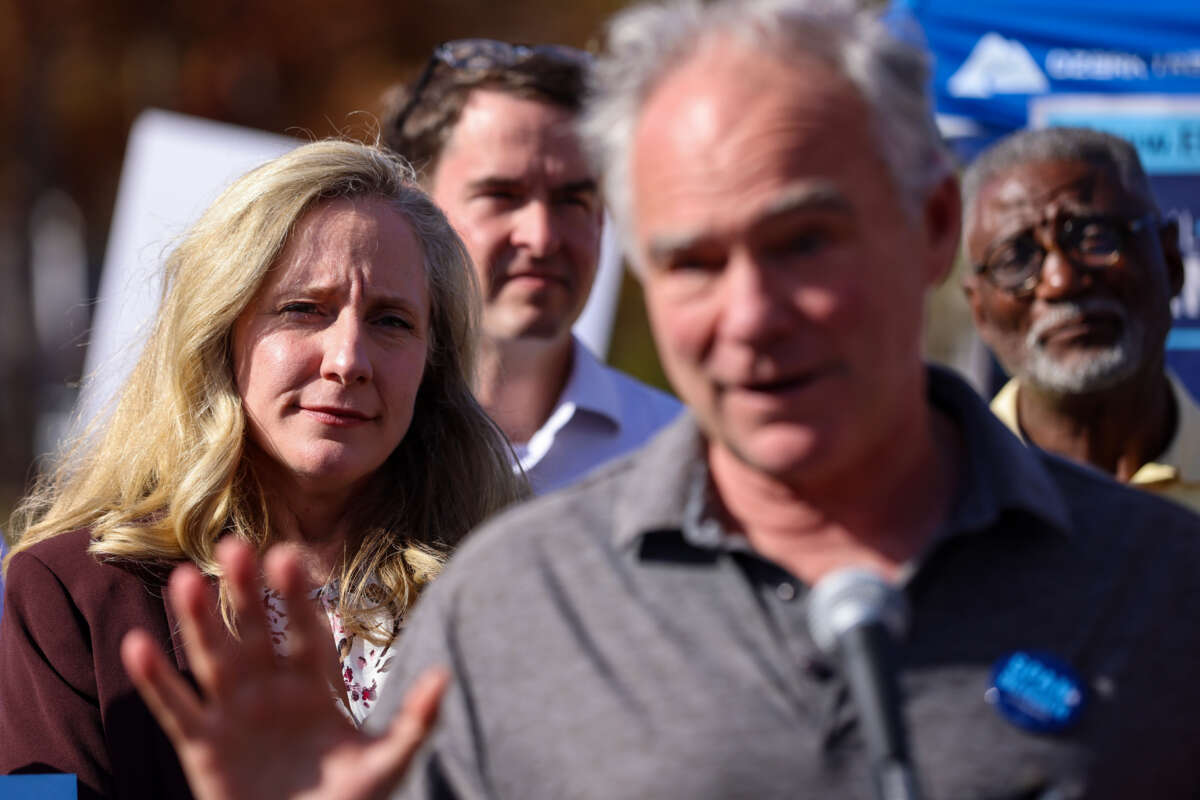 Sen. Tim Kaine speaks while Rep. Abigail Spanberger listens on as volunteers prepare to go door to door on November 5, 2022, in Woodbridge, Virginia.