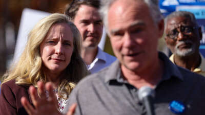 Sen. Tim Kaine speaks while Rep. Abigail Spanberger listens on as volunteers prepare to go door to door on November 5, 2022, in Woodbridge, Virginia.