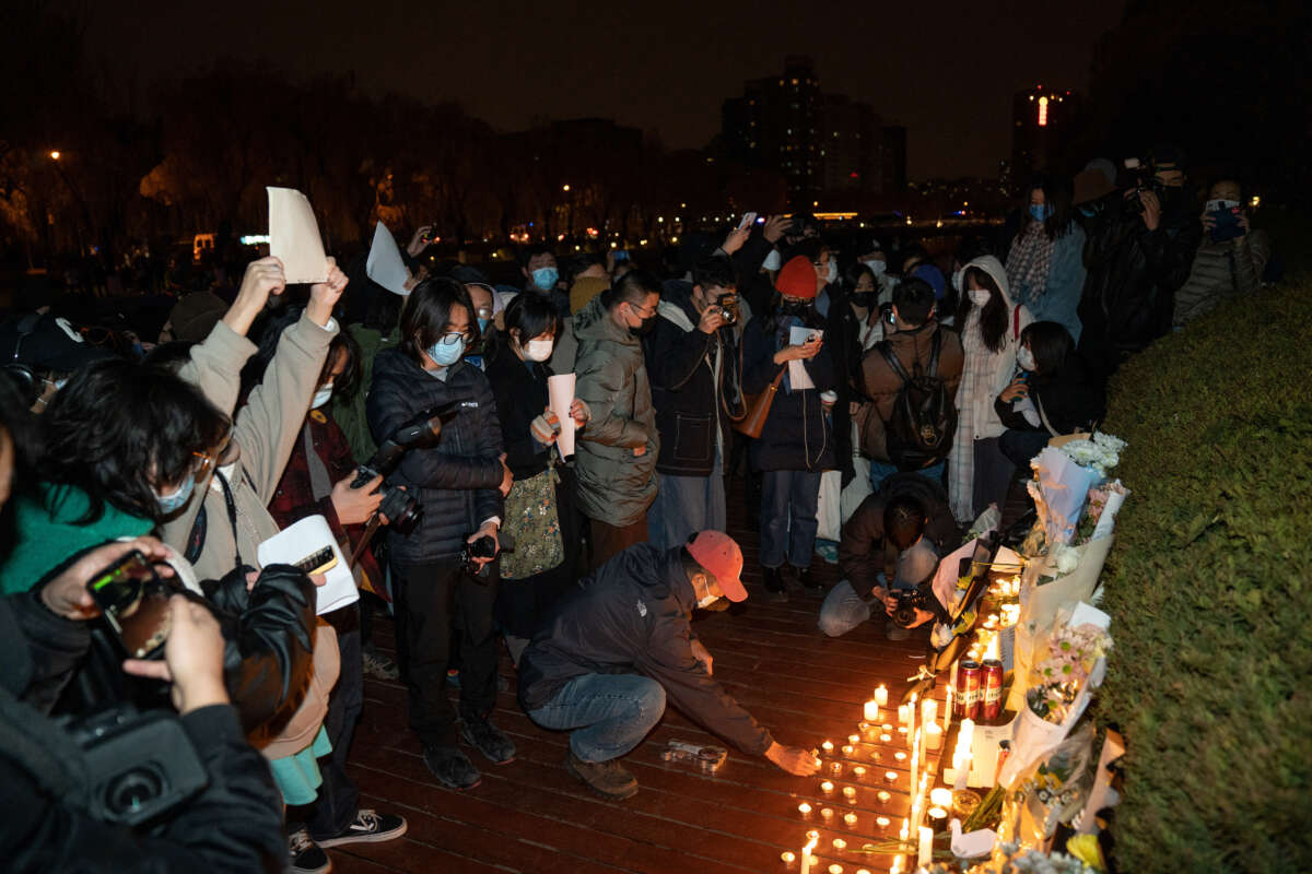 Demonstrators light candles during a vigil to mourn the victims of the Urumqi fire in Beijing, China, on November 27, 2022.