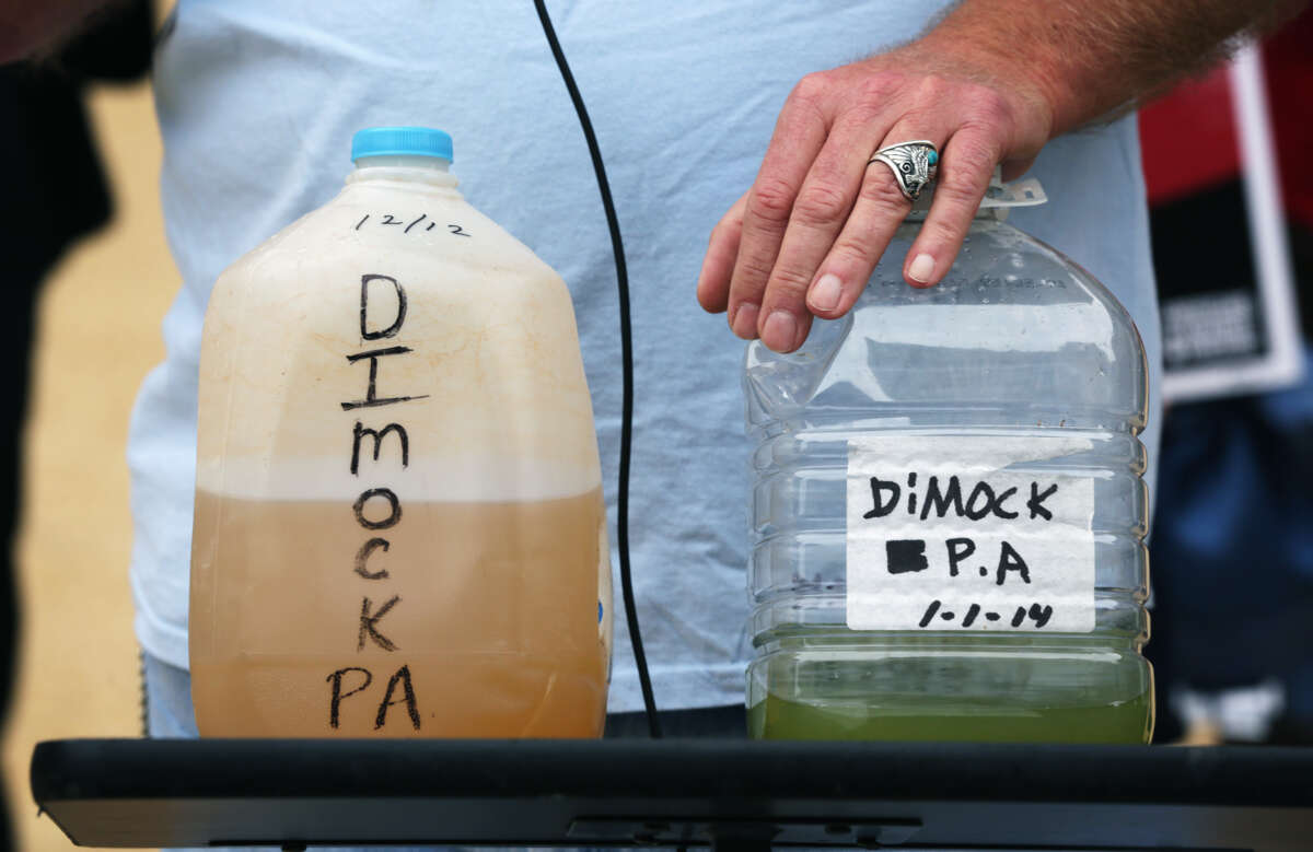 Two bottles labeled "DIMOCK, PA" and filled with brown and green liquid sit on a table
