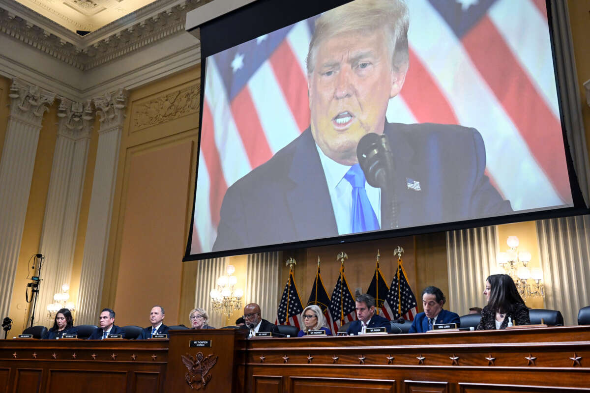 Donald Trump is seen on a projector behind the January 6th commission
