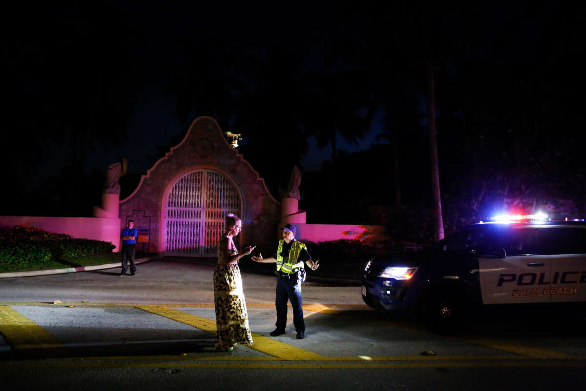 A woman talks to Palm Beach police officer in front of former President Donald Trump's house at Mar-A-Lago on August 8, 2022, in Palm Beach, Florida.