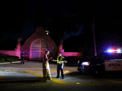 A woman talks to Palm Beach police officer in front of former President Donald Trump's house at Mar-A-Lago on August 8, 2022, in Palm Beach, Florida.