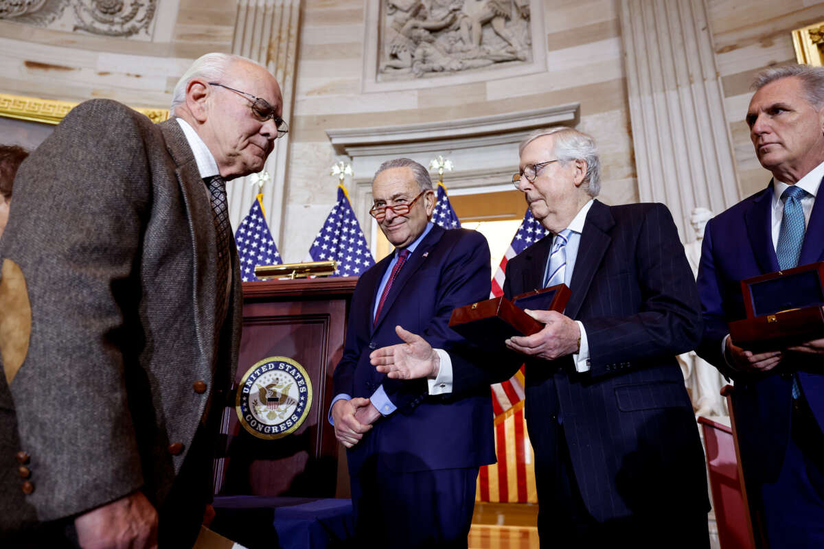 Mitch Mcconnell holds out his hand to greet an older gentlemen who is pointedly looking past him