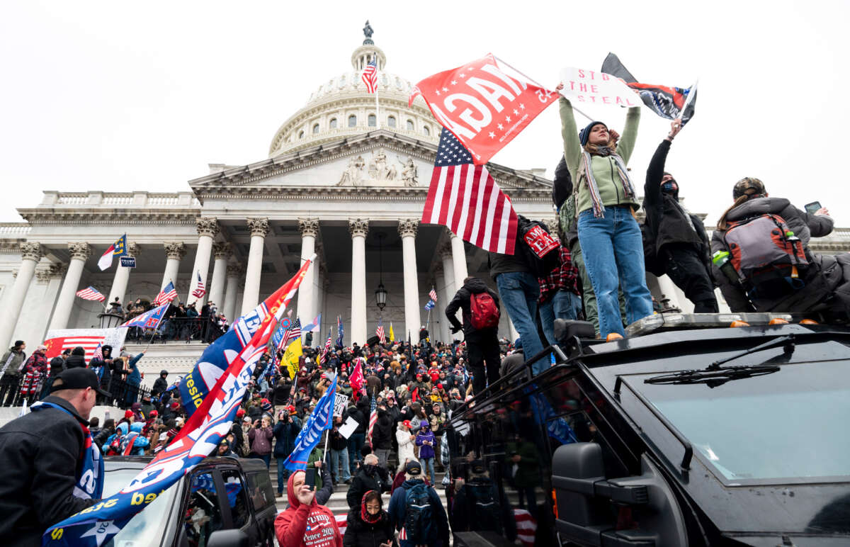Trump supporters stand on the U.S. Capitol Police armored vehicle as others take over the steps of the Capitol on January 6, 2021, as the Congress works to certify the electoral college votes.