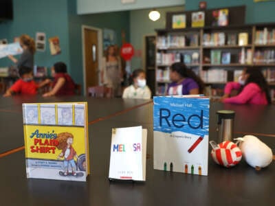 Three books are displayed on a library table