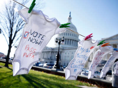 Onesies with messages in support of The Pregnant Workers Fairness Act hang on a clothesline outside the U.S. Capitol during a demonstration on December 1, 2022, in Washington, D.C.