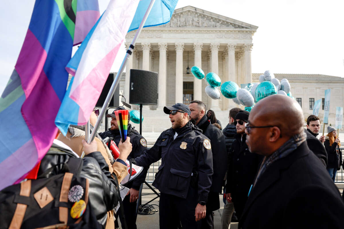 Police officers stand between LGBTQ rights supporters and supporters of web designer Lorie Smith in front of the U.S. Supreme Court Building on December 5, 2022, in Washington, D.C.