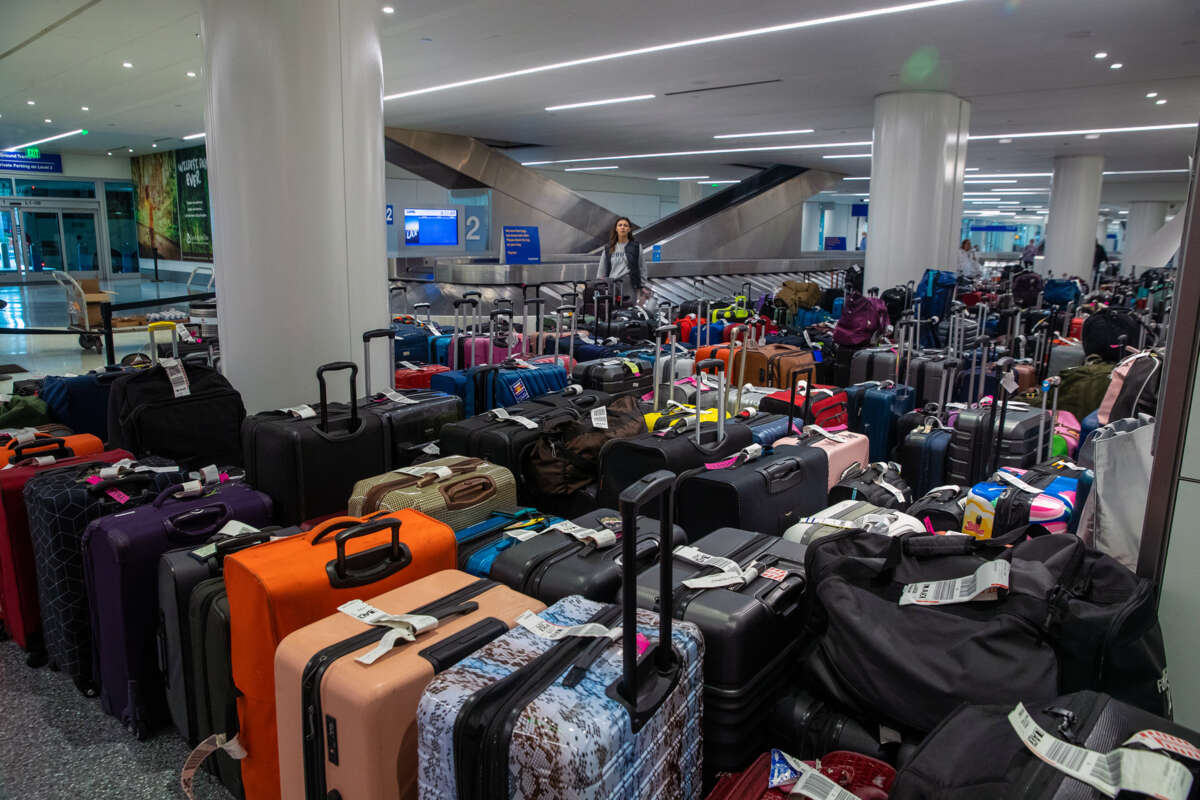 A traveler looks at a daunting array of unclaimed luggage