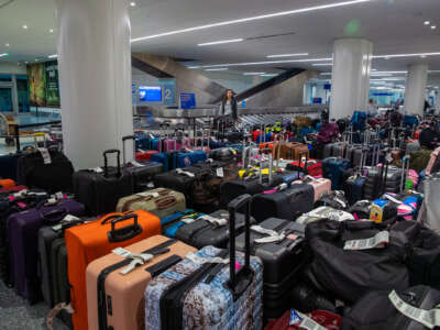 A traveler looks at a daunting array of unclaimed luggage