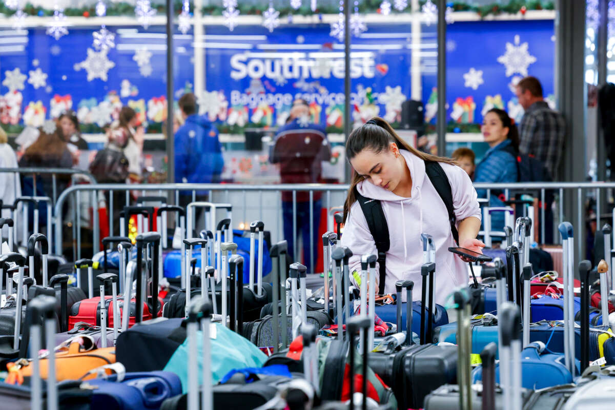 Pristine Floyde searches for a friend's suitcase in a baggage holding area for Southwest Airlines at Denver International Airport on December 28, 2022, in Denver, Colorado.