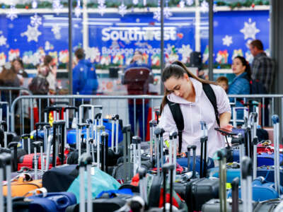 Pristine Floyde searches for a friend's suitcase in a baggage holding area for Southwest Airlines at Denver International Airport on December 28, 2022, in Denver, Colorado.
