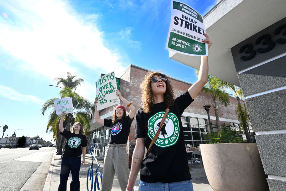 From left, Kit Kittleson, Josie Serrano and Misha Spencer hold picket signs as they strike in front of a Starbucks in Long Beach on December 16, 2022.