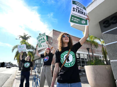 From left, Kit Kittleson, Josie Serrano and Misha Spencer hold picket signs as they strike in front of a Starbucks in Long Beach on December 16, 2022.