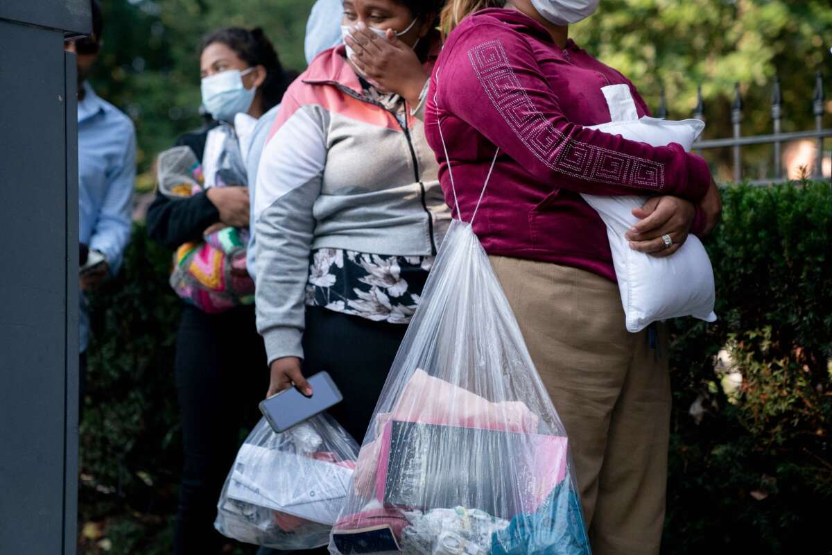 Migrants from Venezuela, who boarded a bus in Texas, wait to be transported to a local church by volunteers after being dropped off outside the residence of US Vice President Kamala Harris, at the Naval Observatory in Washington, D.C, on September 15, 2022.