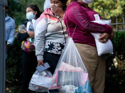 Migrants from Venezuela, who boarded a bus in Texas, wait to be transported to a local church by volunteers after being dropped off outside the residence of US Vice President Kamala Harris, at the Naval Observatory in Washington, D.C, on September 15, 2022.