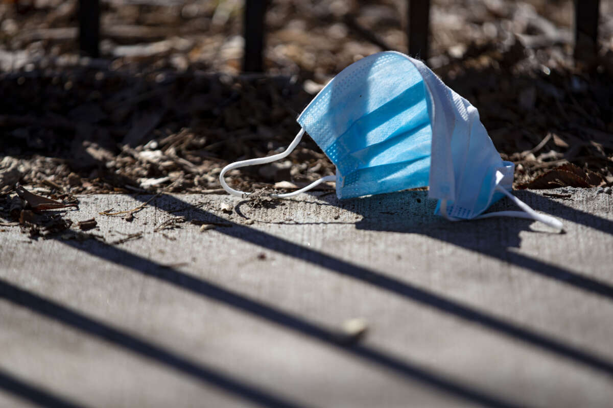 A discarded surgical mask lies on the sidewalk in Chicago, Illinois on April 1, 2020.