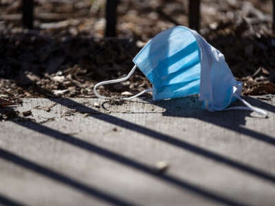 A discarded surgical mask lies on the sidewalk in Chicago, Illinois on April 1, 2020.