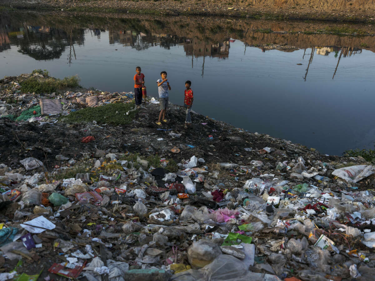 Children playing amid plastic waste on the side of the highly polluted Burigonga river in Bangladesh on November 14, 2022.