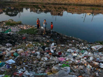 Children playing amid plastic waste on the side of the highly polluted Burigonga river in Bangladesh on November 14, 2022.