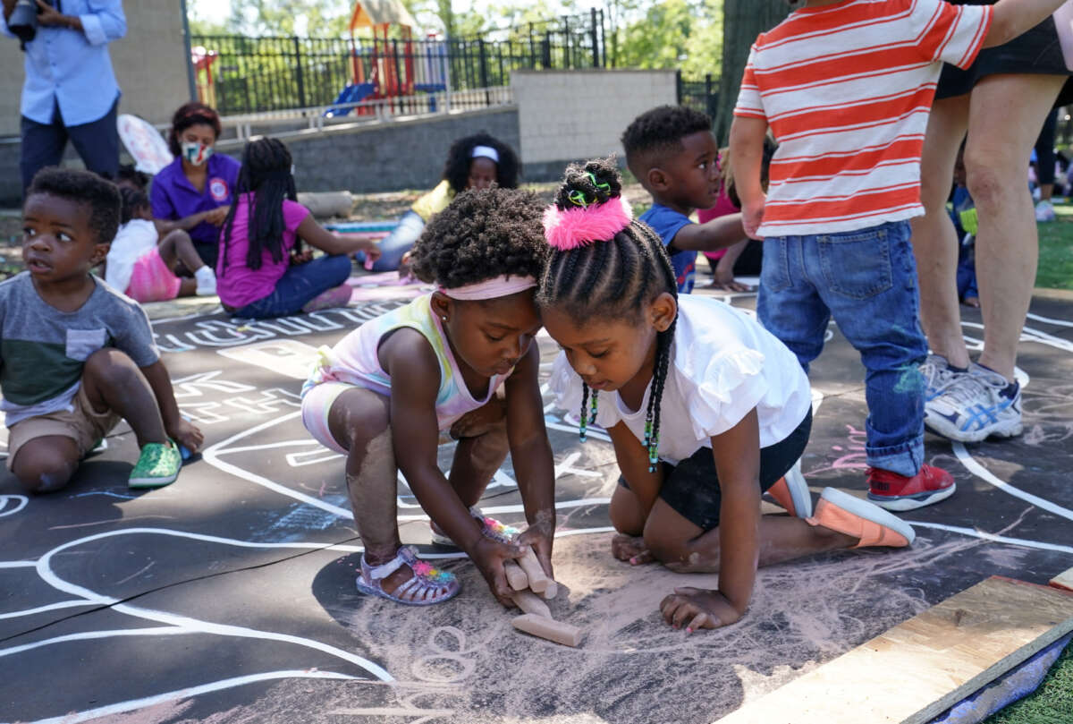 Children and teachers from the KU Kids Deanwood Childcare Center complete a mural in celebration of the launch of the Child Tax Credit on July 14, 2021 in Washington, DC.