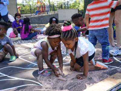 Children and teachers from the KU Kids Deanwood Childcare Center complete a mural in celebration of the launch of the Child Tax Credit on July 14, 2021 in Washington, DC.