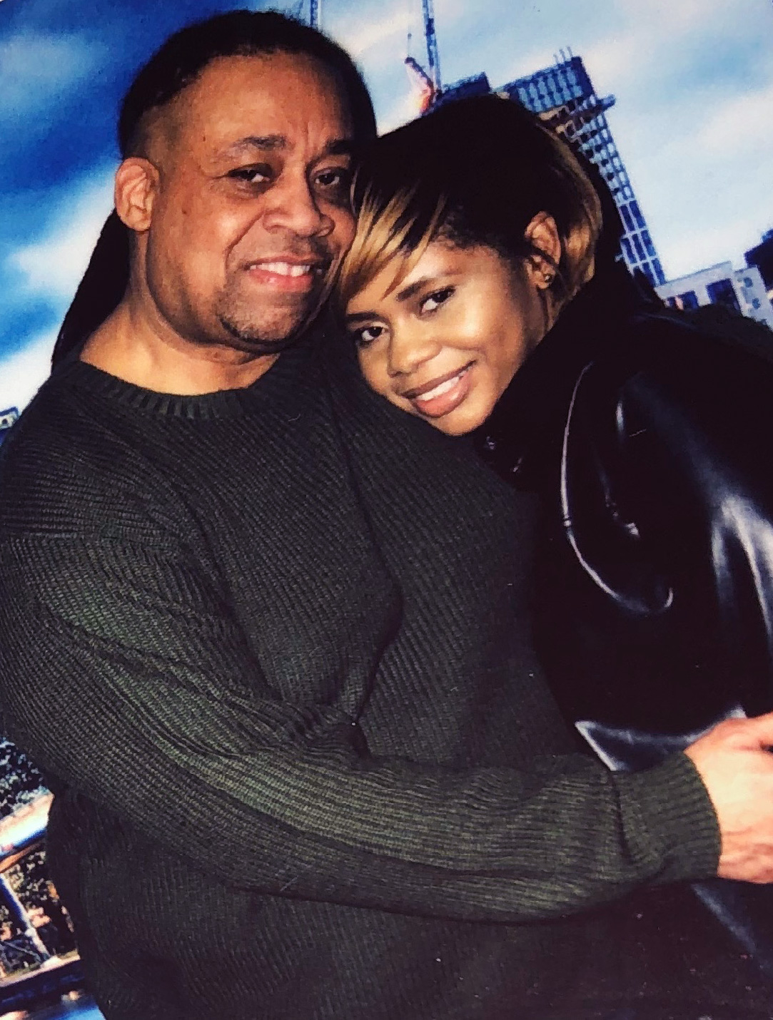 A man embraces his daughter in a studio photo