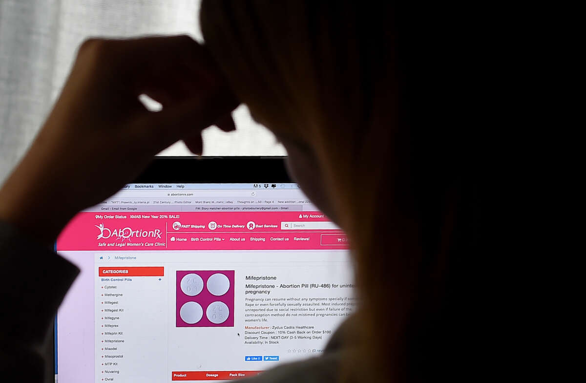 A person looks at a website homepage discussing the abortion pill