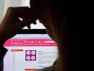 A person looks at a website homepage discussing the abortion pill