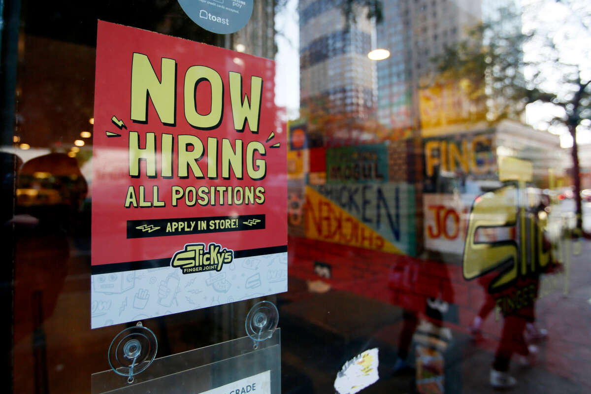 A Now Hiring sign is displayed on a shopfront on October 21, 2022, in New York City.