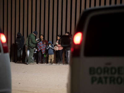 A Border Patrol agent processes asylum-seekers at a gap in the U.S.-Mexico border fence near Somerton, Arizona, on December 26, 2022.