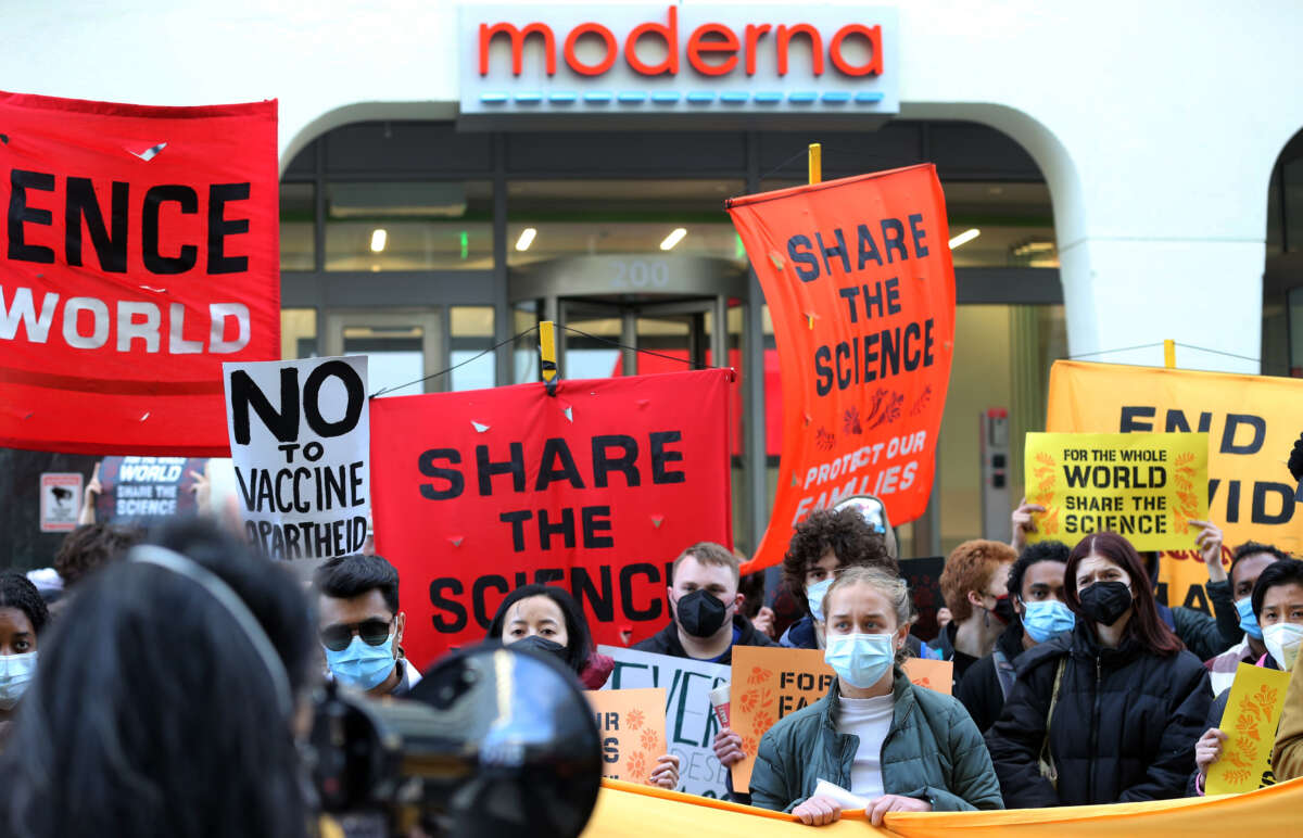 Demonstrators listen to a speaker during a protest in front of Moderna headquarters in Cambridge, Massachusetts, on April 28, 2022.